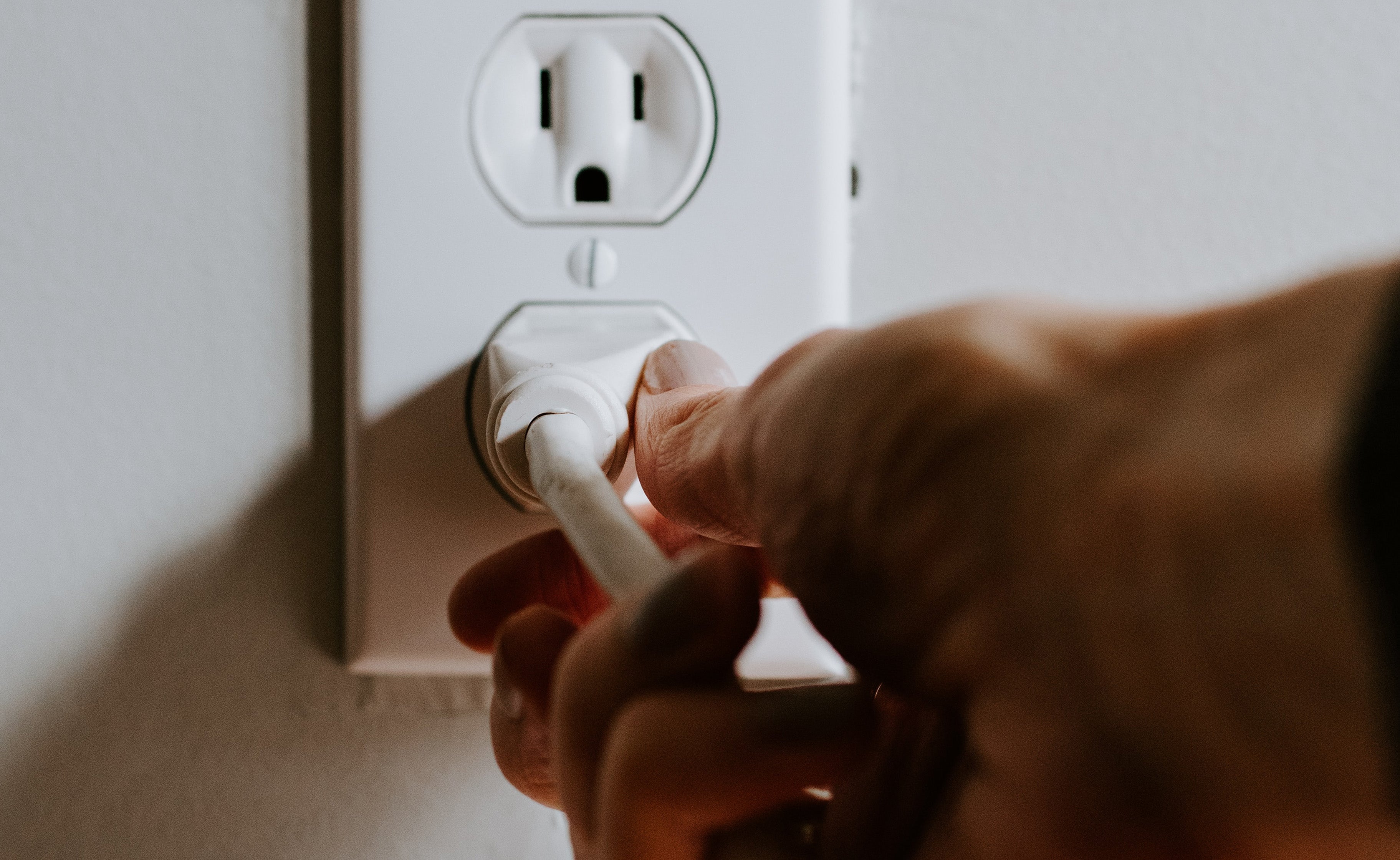 Hand pulling plug from outlet