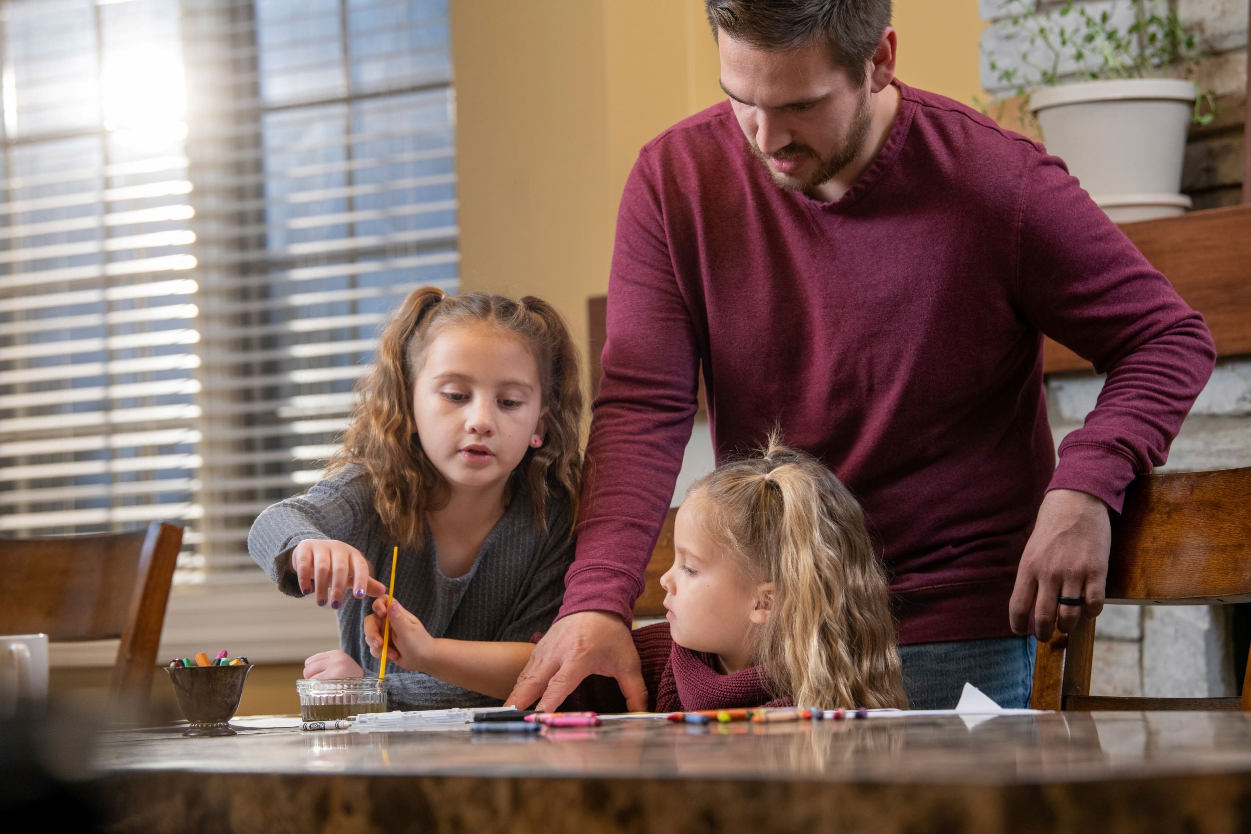 Father with two children as they color at a Hope's Harbor house