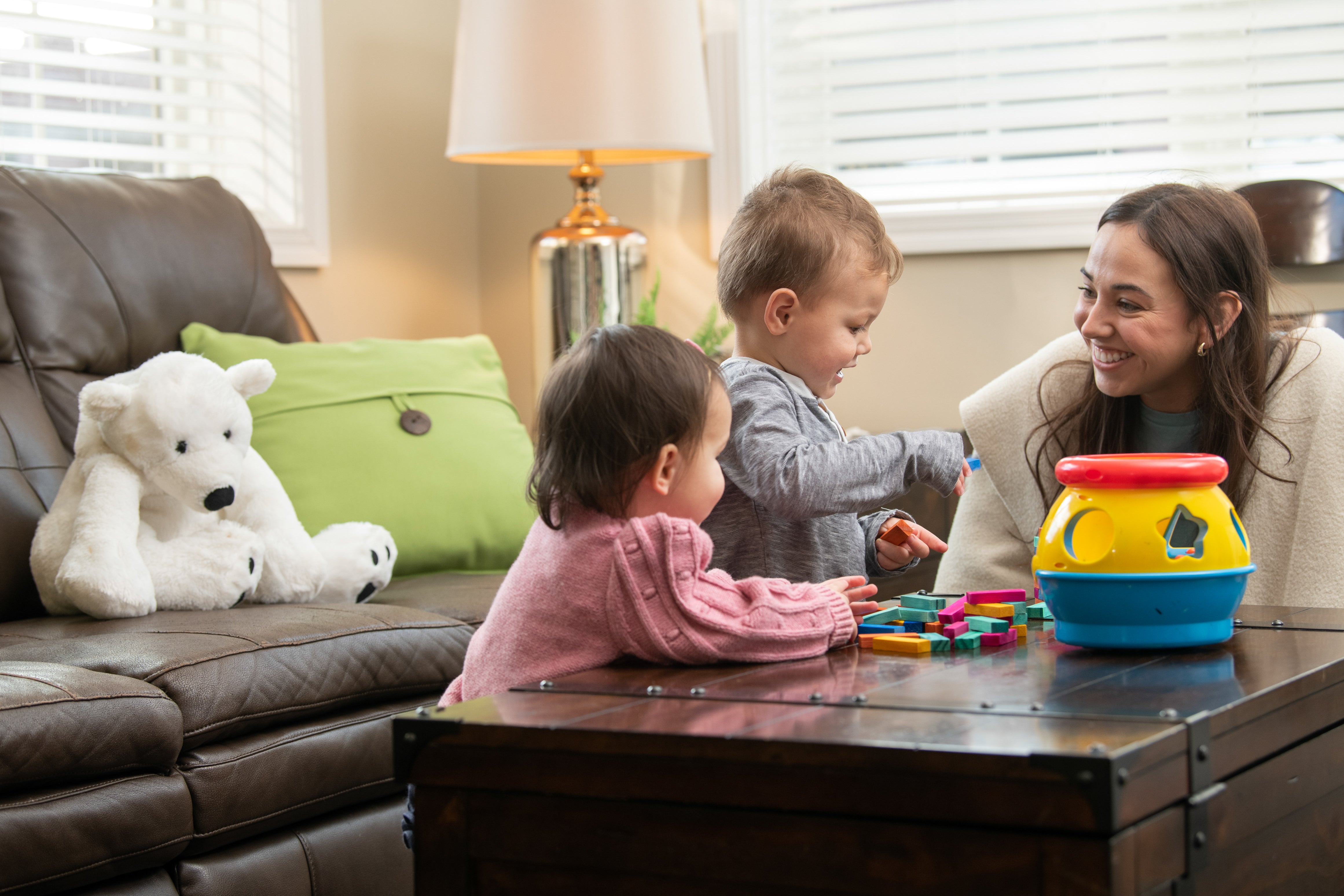 Adult playing with two toddler guests at Hope's Harbor